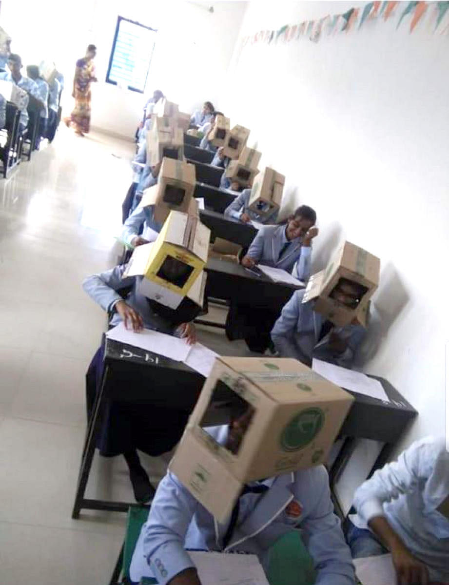 Students made to wear cartons on their heads to prevent them from copying at a college in Haveri on Friday.