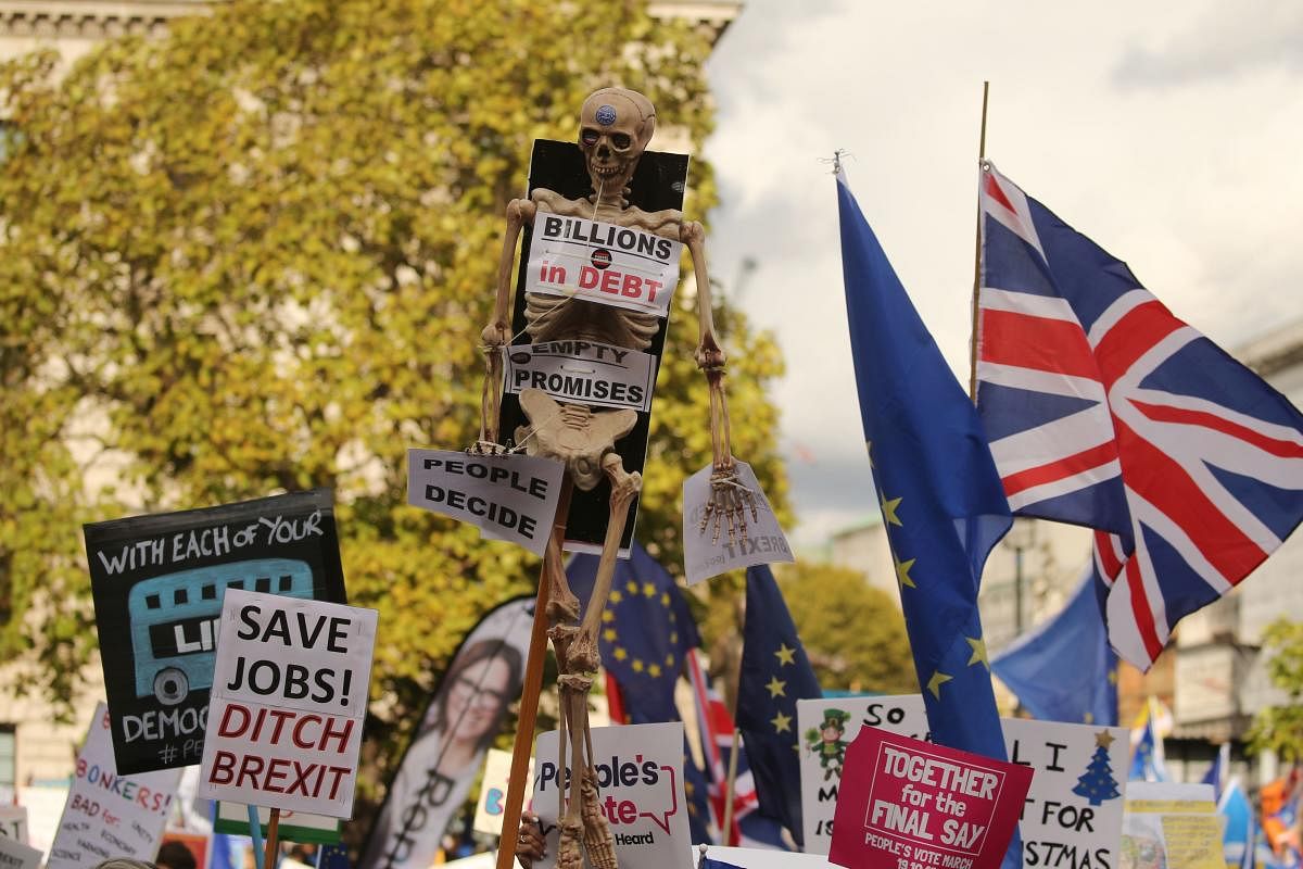 Demonstrators with placards and EU and Union flags gather in Parliament Square in central London on October 19, 2019, as they take part in a rally by the People's Vote organisation calling for a final say in a second referendum on Brexit. - Thousands of people march to parliament calling for a "People's Vote", with an option to reverse Brexit as MPs hold a debate on Prime Minister Boris Johnson's Brexit deal. AFP