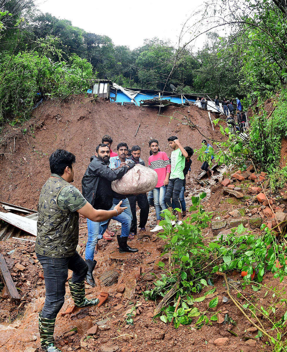 Volunteers shift salvaged articles from a house destroyed by landslides at Mekeri near Madikeri on Monday. DH PHOTO/Krishnakumar P S.