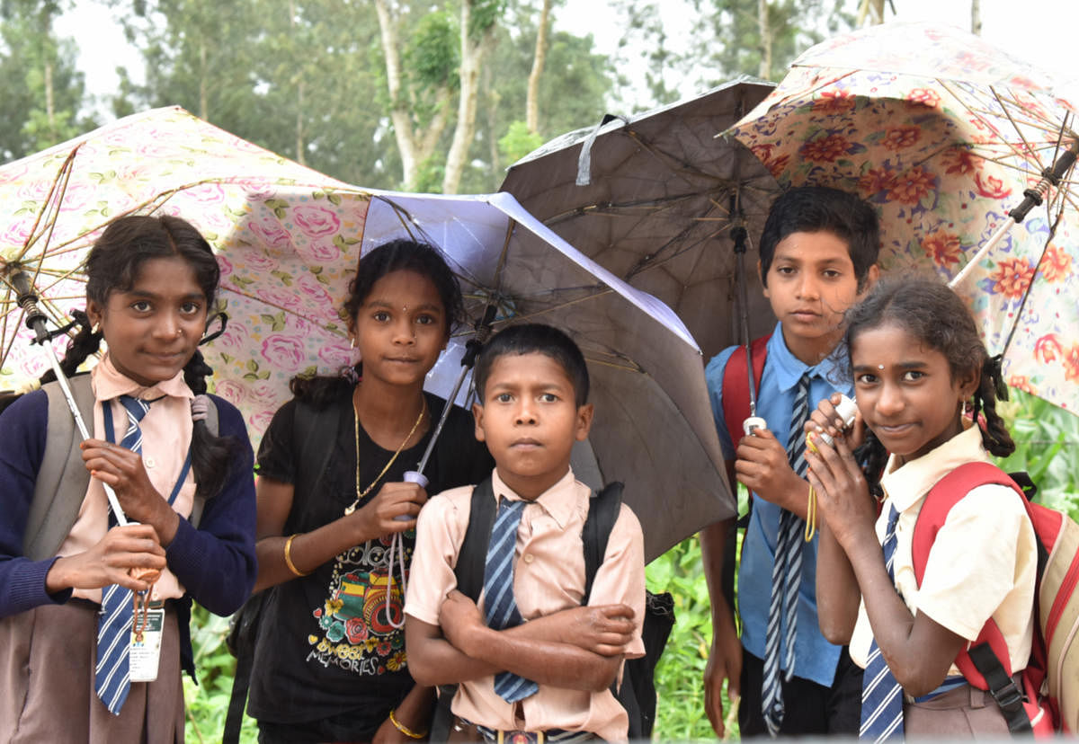 School Children are walking in the rain as few schools started in Madikeri on Thursday. Photo/ B H Shivakumar