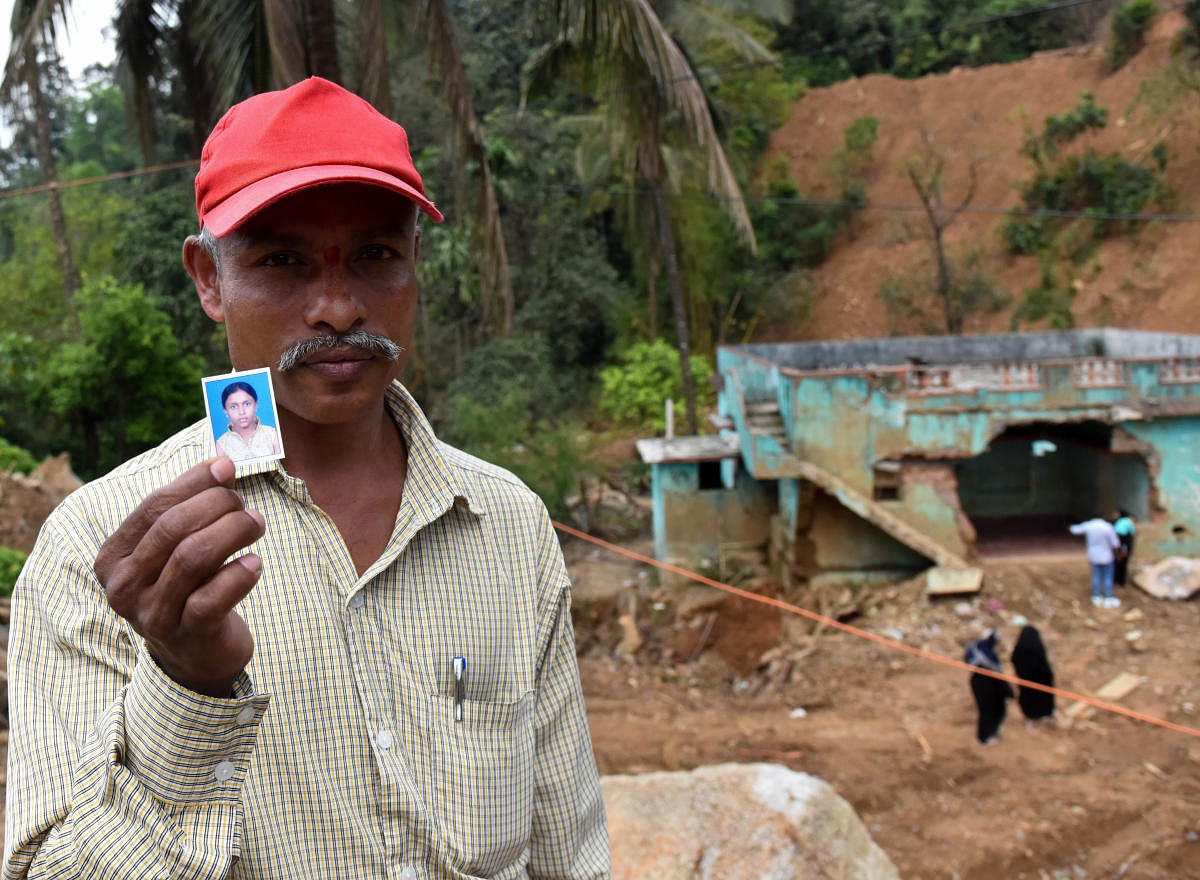 Somaiah shows a photo of his missing daughter Manjula whose body has not yet been recovered after massive landslides destroyed Jodupala village in Kodagu last month. DH Photo/B H Shivakumar