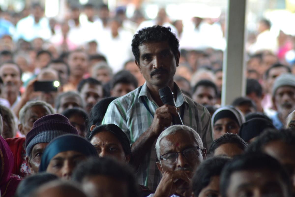 A flood victim speaks during an interaction with Chief Minister H D Kumaraswamy at Gandhi Maidan in Madikeri on Wednesday.