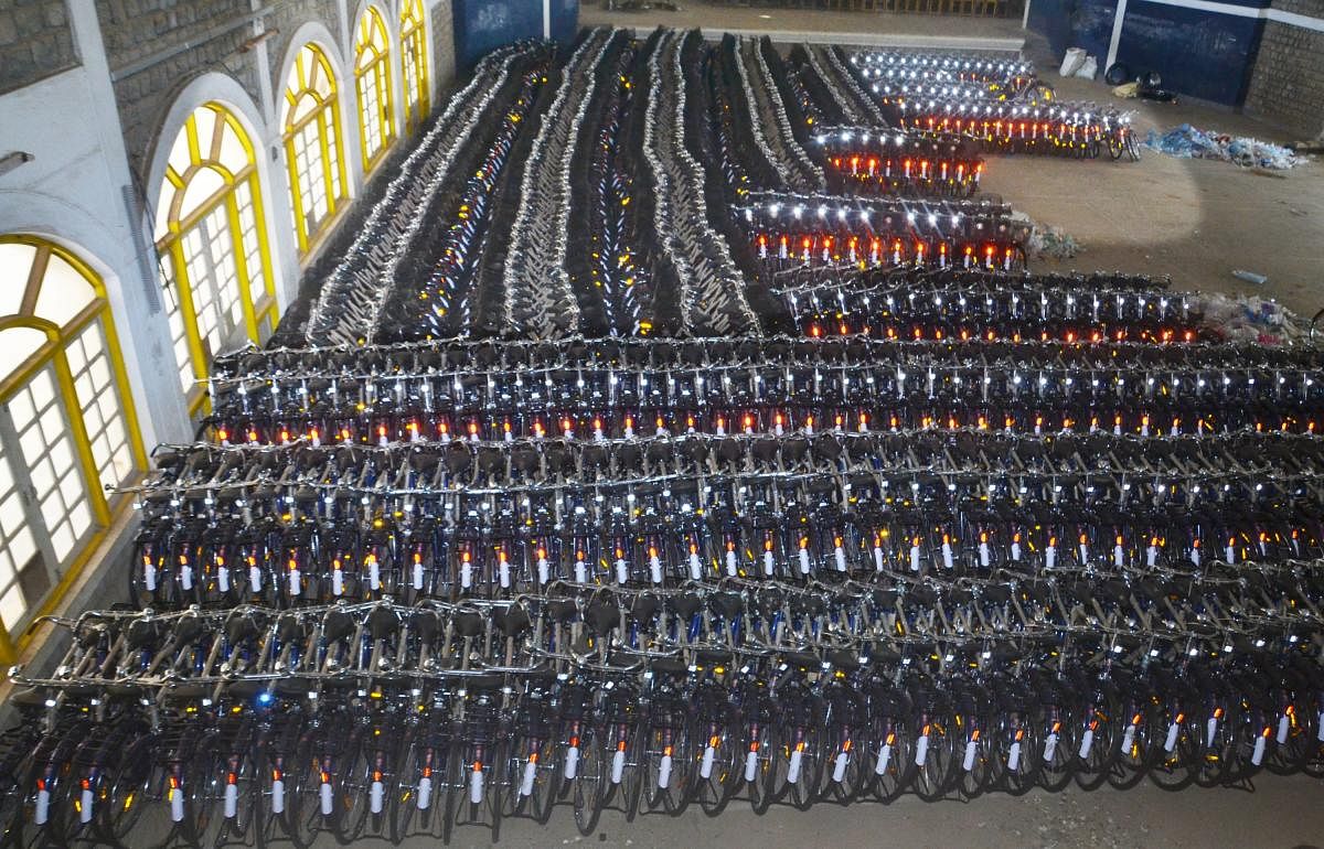 Bicycles ready for distribution among schoolchildren neatly arranged at Field Marshal K M Cariappa Indoor Stadium in Madikeri.