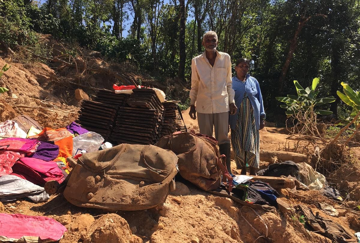 In tatters: Eeshwara and his wife Kaveramma gathered soiled belongings after digging the debris of their house at Emmetalu-Makkandur village in Kodagu district.dh photo/ambarish v