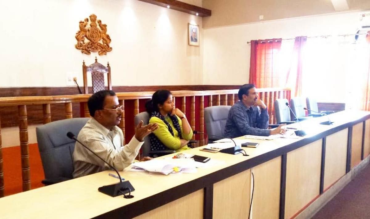 Labour officer Ramakrishna speaks at a meeting in Madikeri. Superintendent of Police Suman D Pennekar looks on.