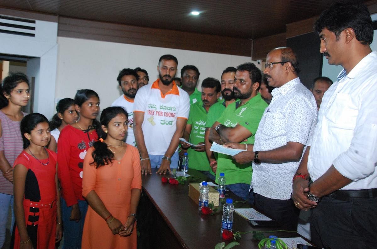 People for People organisation hands over financial assistance to the natural calamity affected students, towards their studies, in Madikeri on Tuesday.