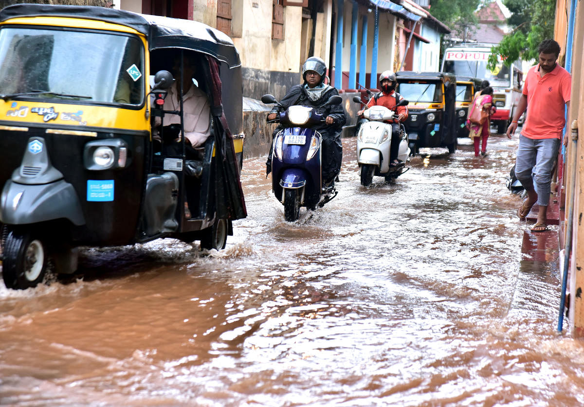Motorists navigate through a waterlogged road in Mangaluru, following heavy rain.