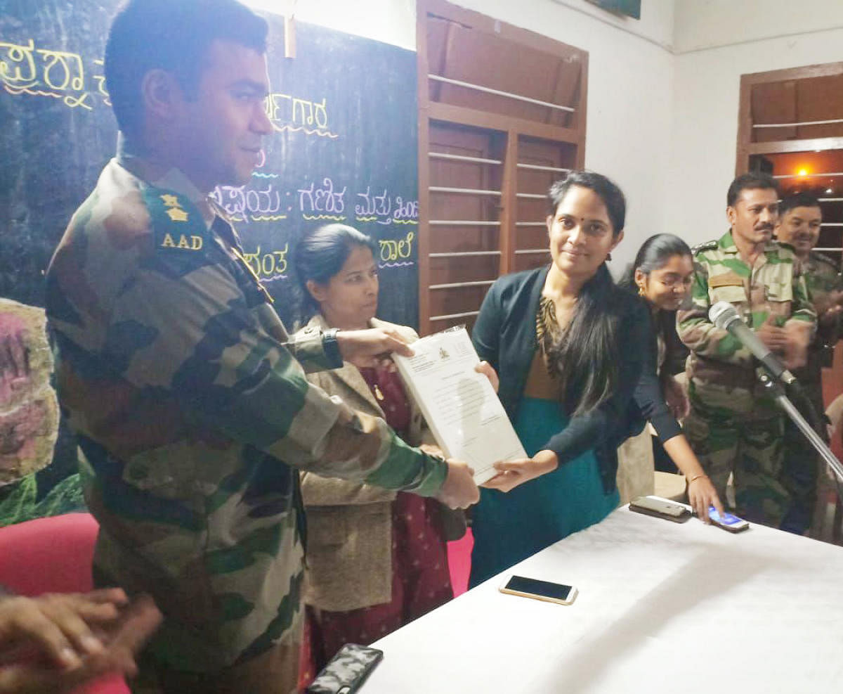 Deputy Commissioner Annies Kanmani Joy presents a certificate to a soldier in Kodagu on Tuesday. SP Dr Suman D Pennekar and ZP CEO K Lakshmi Priya are also seen.