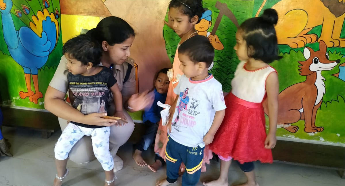 Kodagi Superintendent of Police Suman D Pennekar interacts with children at the anganwadi in Madikeri, where her child Khushi studies.