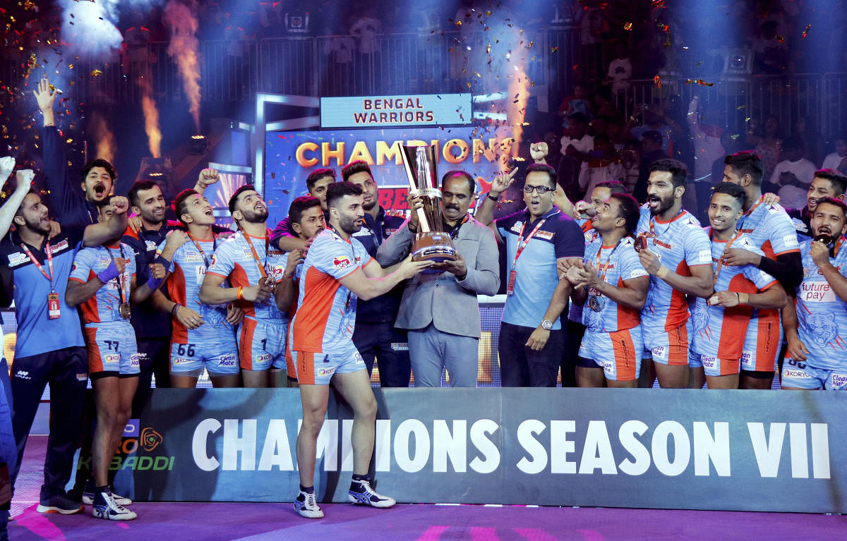 Players and officials of Bengal Warriors celebrate with the trophy after defeating Delhi Dabbang KC during the finals of the seventh edition of Pro-Kabaddi league, in Ahmedabad, Saturday, Oct. 19, 2019. Bengal Warriors beat Dabang Delhi 39-34. (PTI Photo)