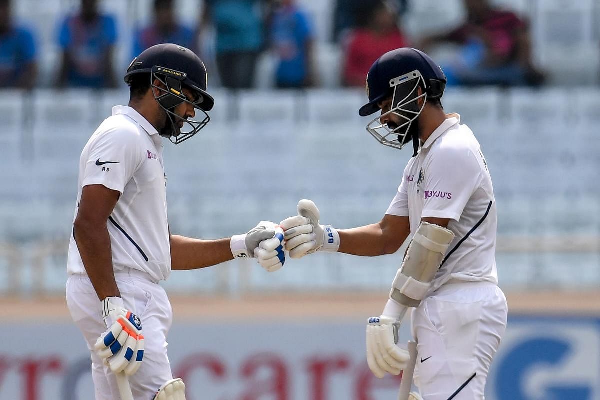 India's Rohit Sharma (L) and teammate Ajinkya Rahane (R) touch gloves during the second day of the third and final Test match between India and South Africa at the Jharkhand State Cricket Association (JSCA) stadium in Ranchi on October 20, 2019. (Photo by AFP)