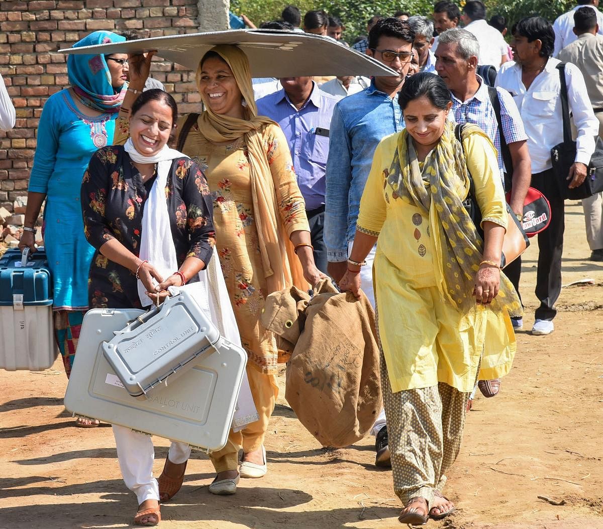 Polling officials, carrying the Electronic Voting Machine (EVMs) and other necessary inputs, leave for their poll duty, on the eve of Haryana Assembly elections, in Sonipat, Sunday, Oct. 20, 2019. (PIB/PTI Photo)