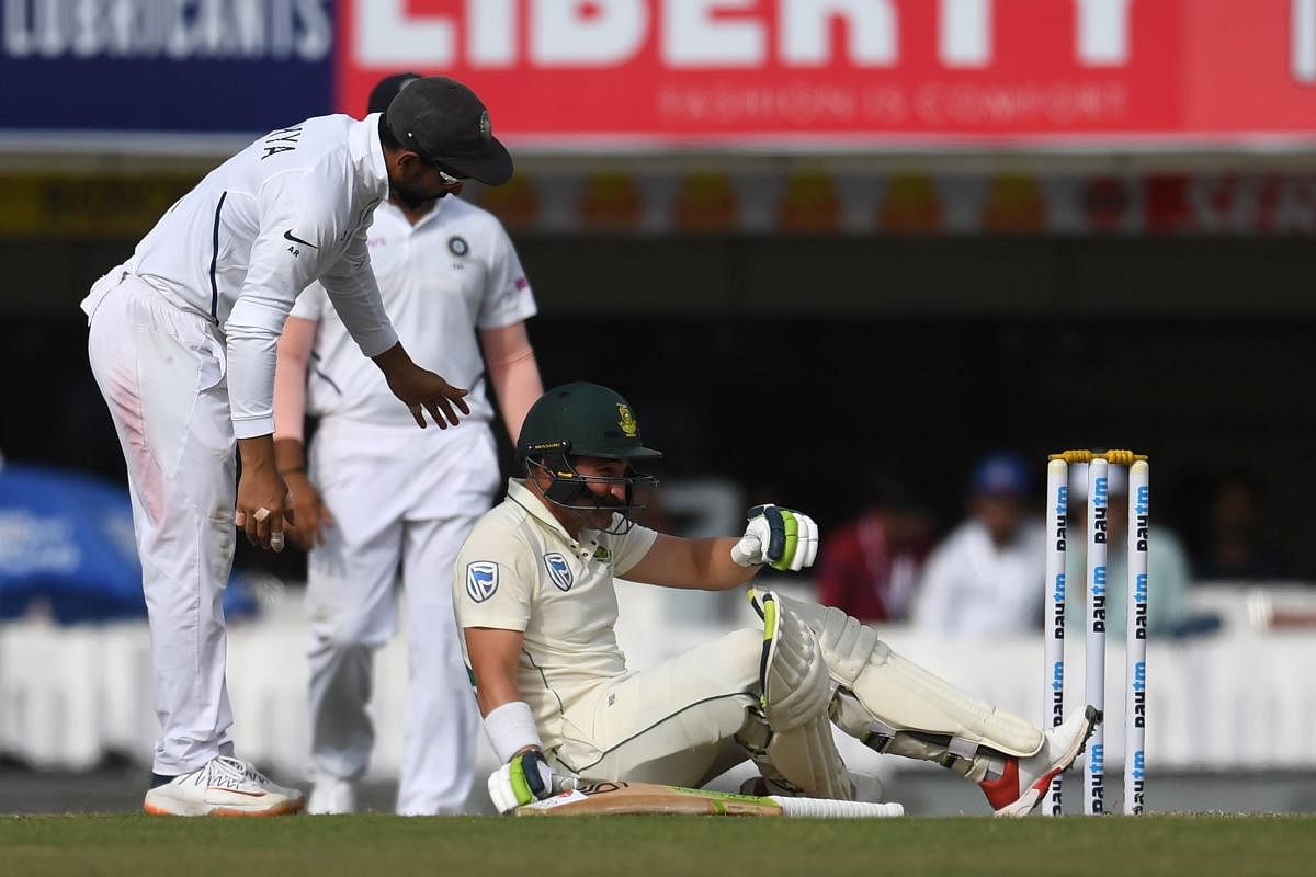 South Africa's Dean Elgar (C) sits on the floor after being hit by a ball during the third day of the third and final test match between India and South Africa at Jharkhand State Cricket Association (JSCA) in Ranchi on October 21, 2019. (AFP)