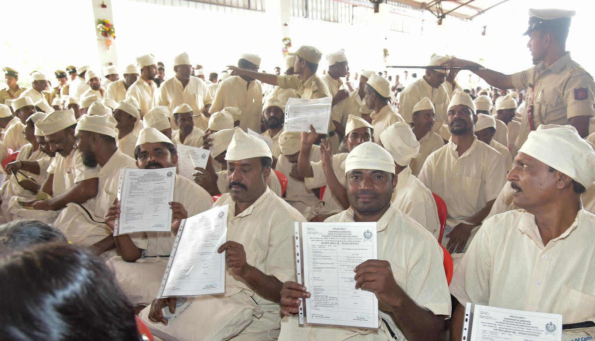 Prisoners released for good conduct show their release certificates at Parappana Agrahara Central Prisons in Bengaluru on Monday. DH Photo/B H Shivakumar