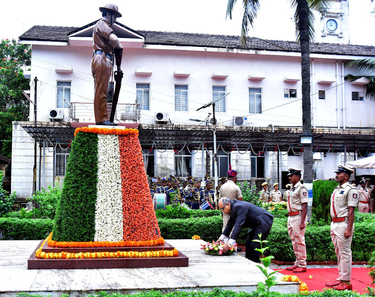 Sessions Judge Kadlooru Satyanarayanacharya pays floral tributes to police martyrs at the memorial in the district police ground in Mangaluru on Monday. 
