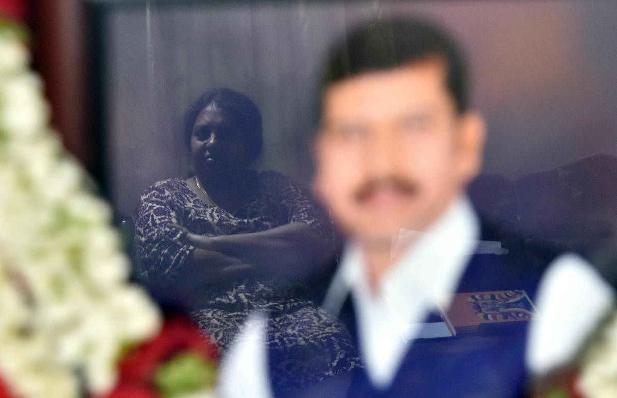 Dr Pavana Dibbur (reflected in glass), wife of Dr Dore, has never stepped into a police station. She hopes justice will be quick. DH Photos by Janardhan B K