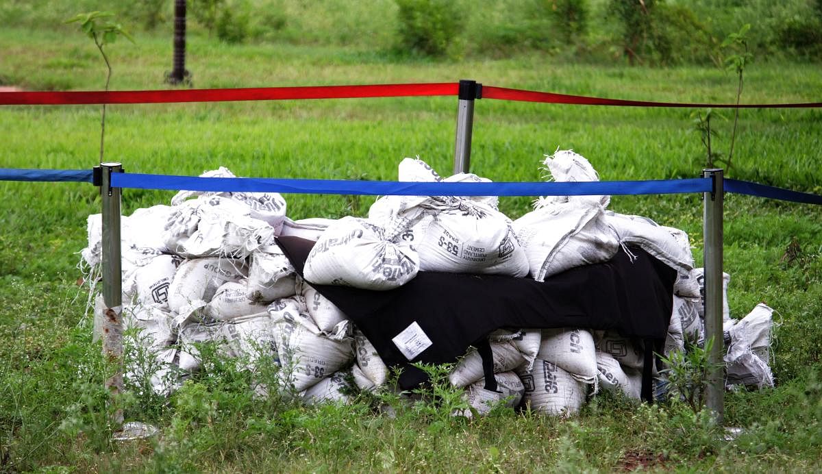 Explosives found in a bucket are kept at an isolated place, covered by sand bags, at the railway station premises in Hubballi.