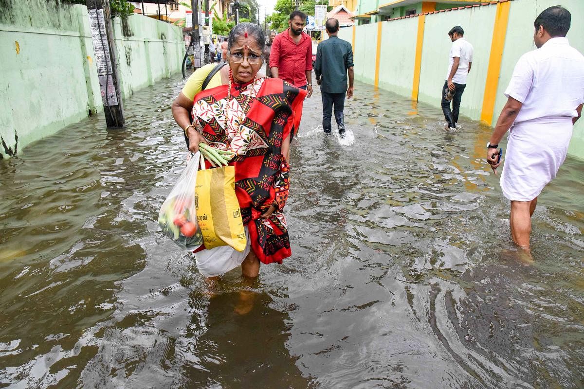 Residents wade through a waterlogged street following heavy rainfall in Kochi, Monday, Oct. 21, 2019. Heavy rains are likely to lash several parts of Kerala as the North East monsoon became active over the state. (PTI Photo)