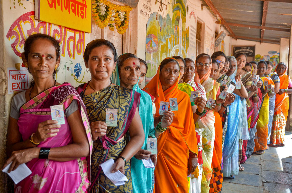 Woman voters display their identity cards as they wait in a queue to cast their votes for Maharashtra Assembly polls, in Sangli, Monday, Oct 21, 2019. (PTI Photo) 