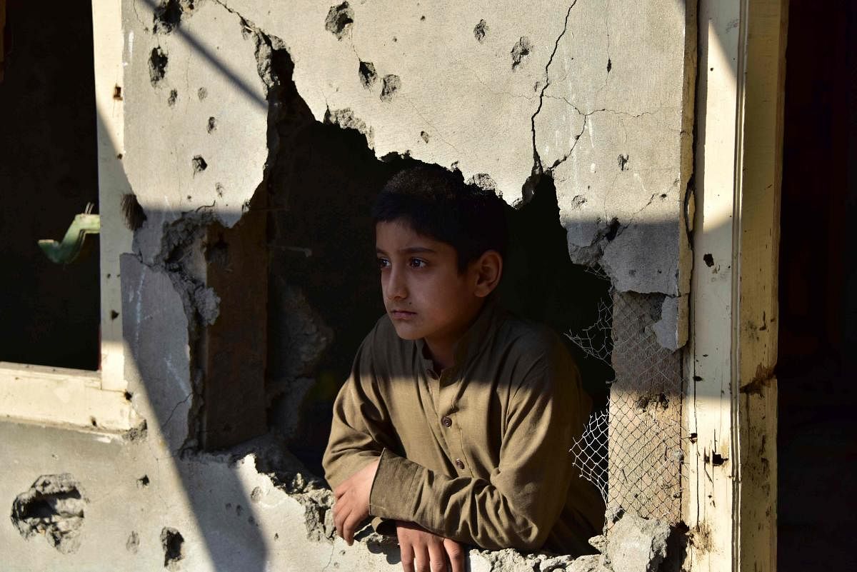 A Kashmiri boy looks out from his damaged family house after cross border shelling in Jura, a village of Neelum valley in Pakistan-administered Kashmir. (Photo by Reuters)