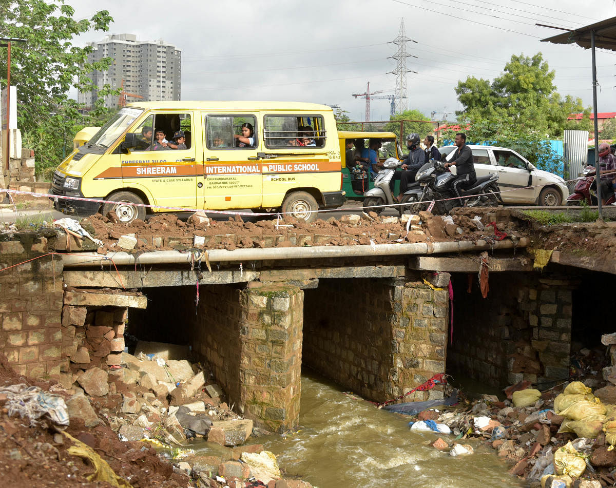 A retaining wall on Nelagadaranahalli Road collapsed following rains on Tuesday night. (DH PHOTO/B H SHIVAKUMAR)