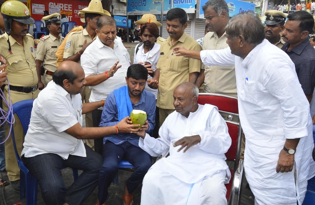 JD(S) national president H D Deve Gowda offers tender coconut to party youth wing leader Sharanagouda Kandakur, who ended his hunger strike, in Yadgir on Wednesday.  