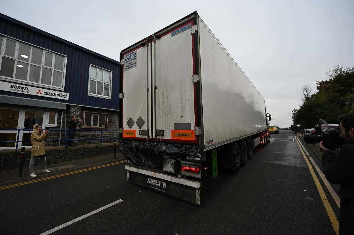 Police officers drive away a lorry, with black plastic visible at the rear, in which 39 dead bodies were discovered sparking a murder investigation at Waterglade Industrial Park in Grays, east of London, on October 23, 2019. AFP