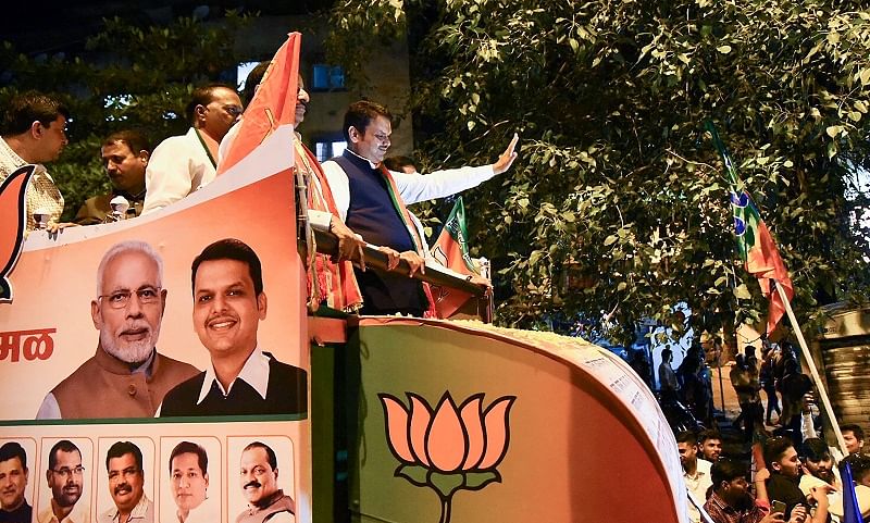 Maharashtra Chief Minister Devendra Fadnavis waves at supporters during a roadshow for BJP candidates for Maharashtra Assembly elections. (PTI Photo)