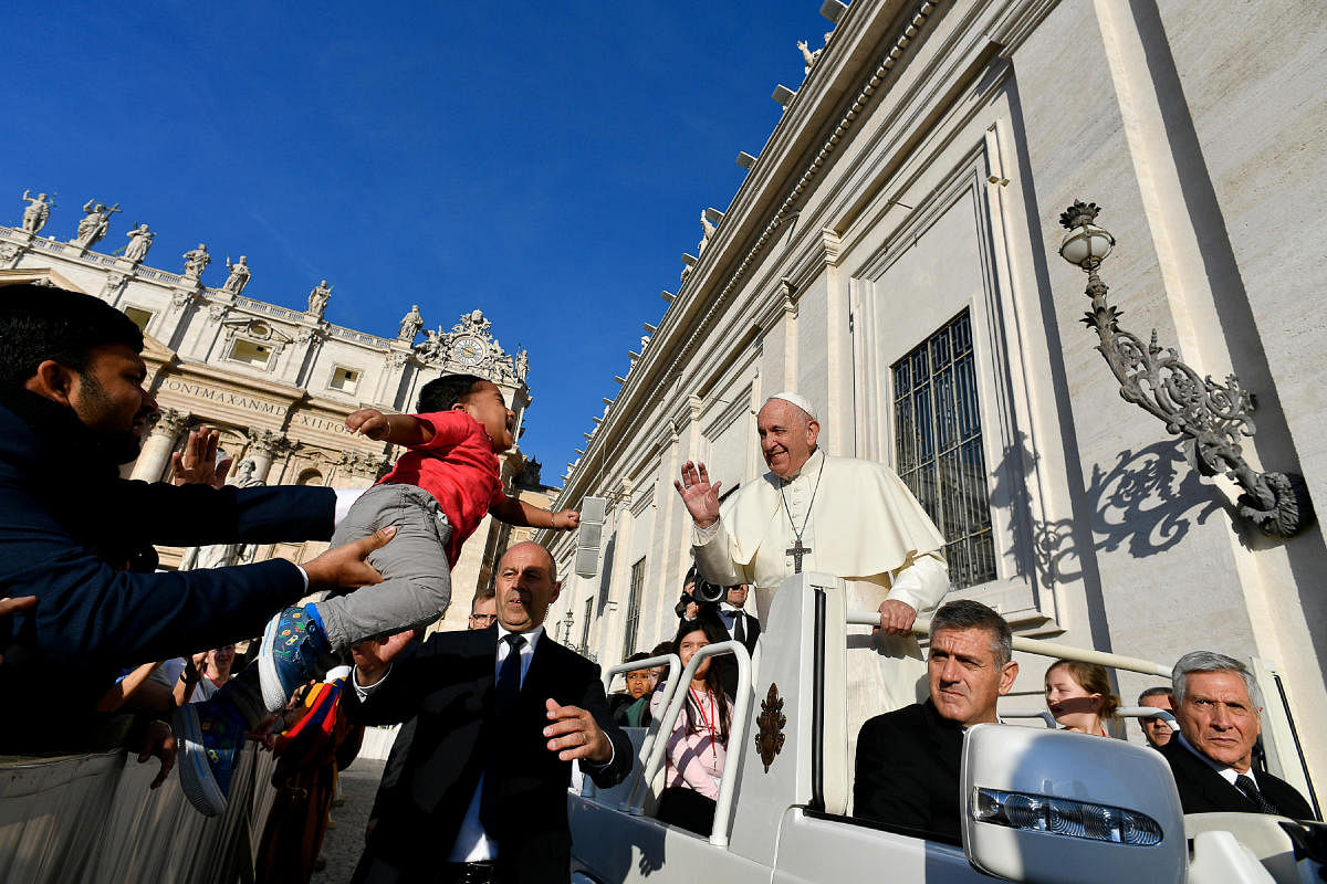 Pope Francis waves to a young child held out to him by a crowd member during the general audience at the Vatican, October 23, 2019. (Photo by Reuters)