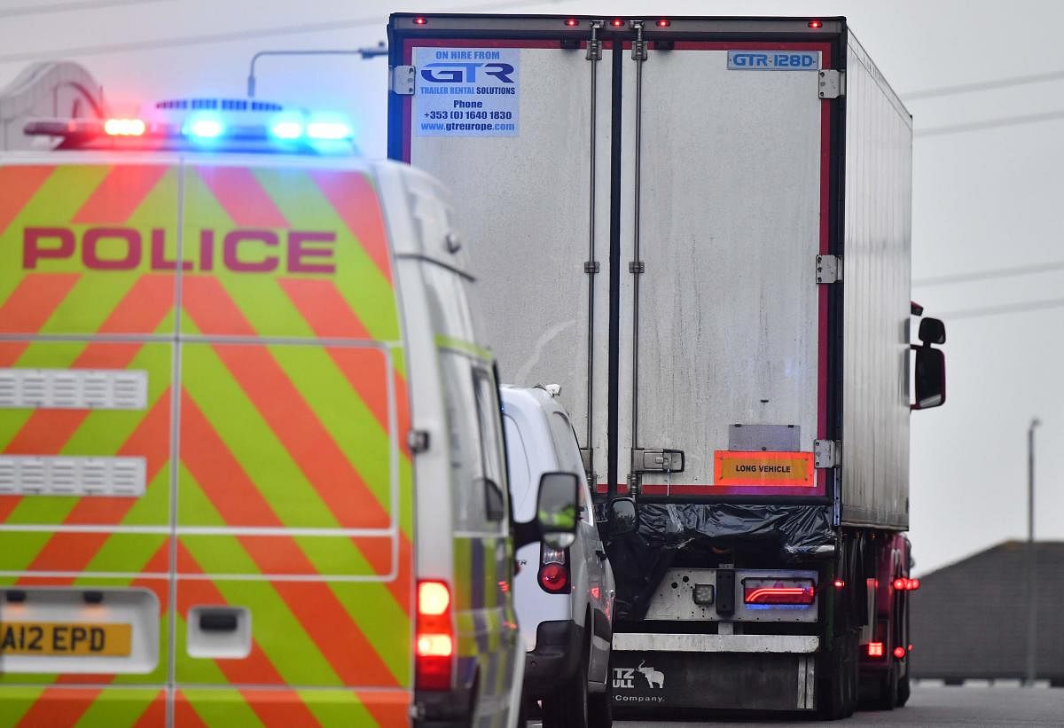 Police officers drive away a lorry, with black plastic visible at the rear, in which 39 dead bodies were discovered sparking a murder investigation at Waterglade Industrial Park in Grays, east of London, on October 23, 2019. (Photo by AFP)