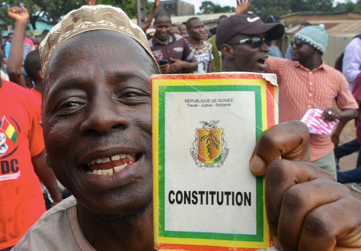 A man holds a copy of Guinea's Constitution as he takes part in a protest against the third term of the Guinean President. (Photo AFP)
