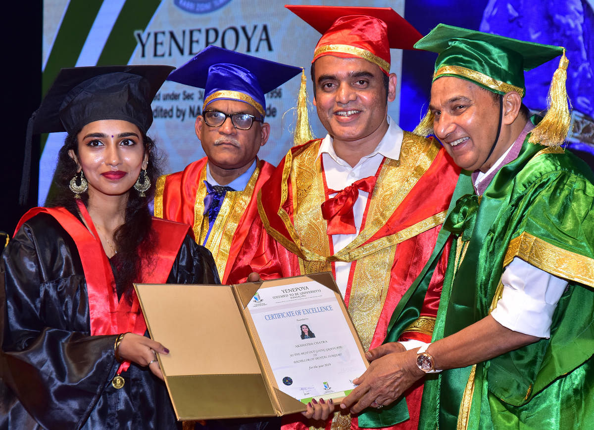 Deputy Chief Minister Dr C N Ashwath Narayan and Yenepoya (Deemed to be University) Chancellor Y Abdulla Kunhi present the gold medal award to best outgoing student Akshatha Chatra, during the ninth convocation, on the university campus in Deralakatte on Friday