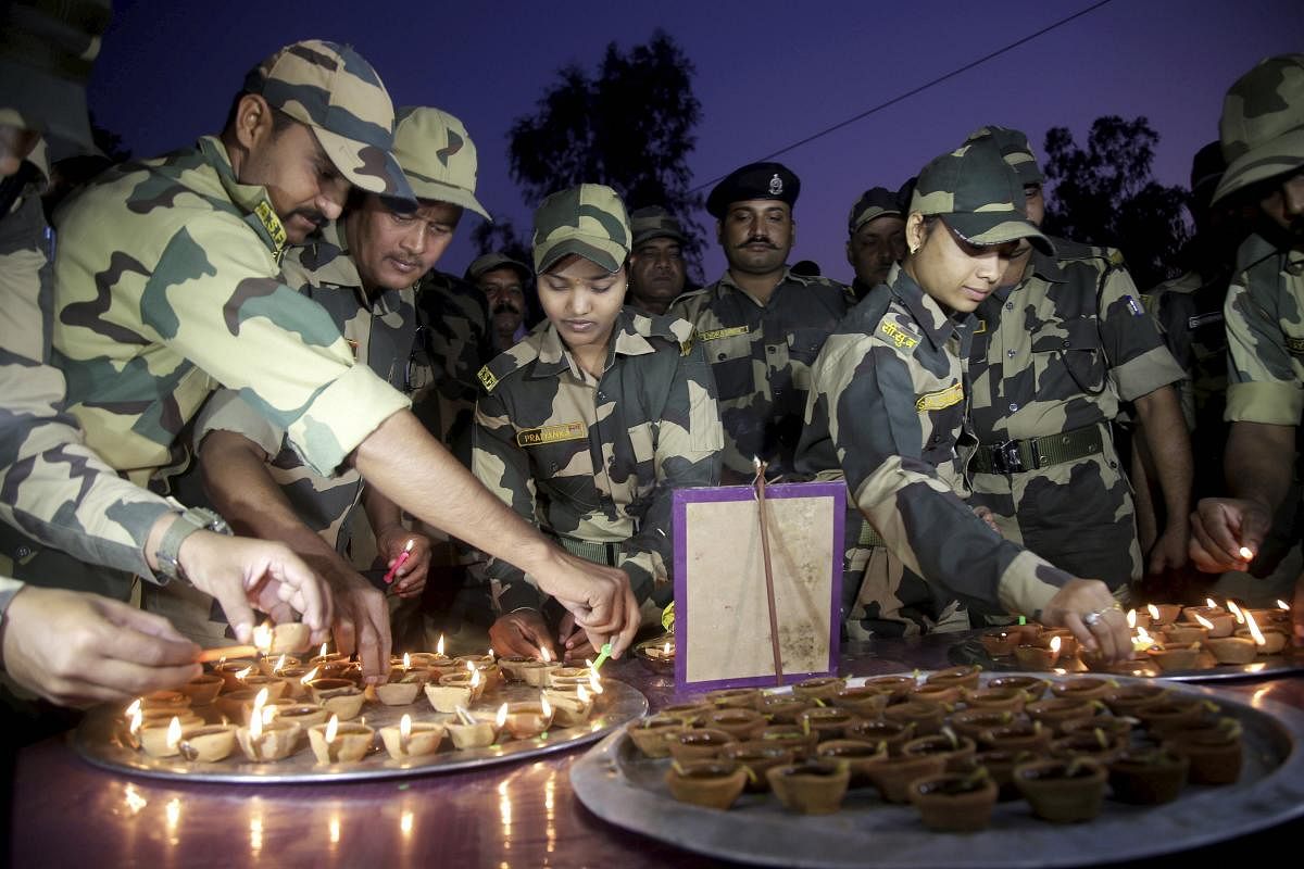 Border Security Force (BSF) soldiers light candles during Diwali celebrations near the international border outskirts in Jammu, Saturday, Oct. 26, 2019. (PTI Photo)
