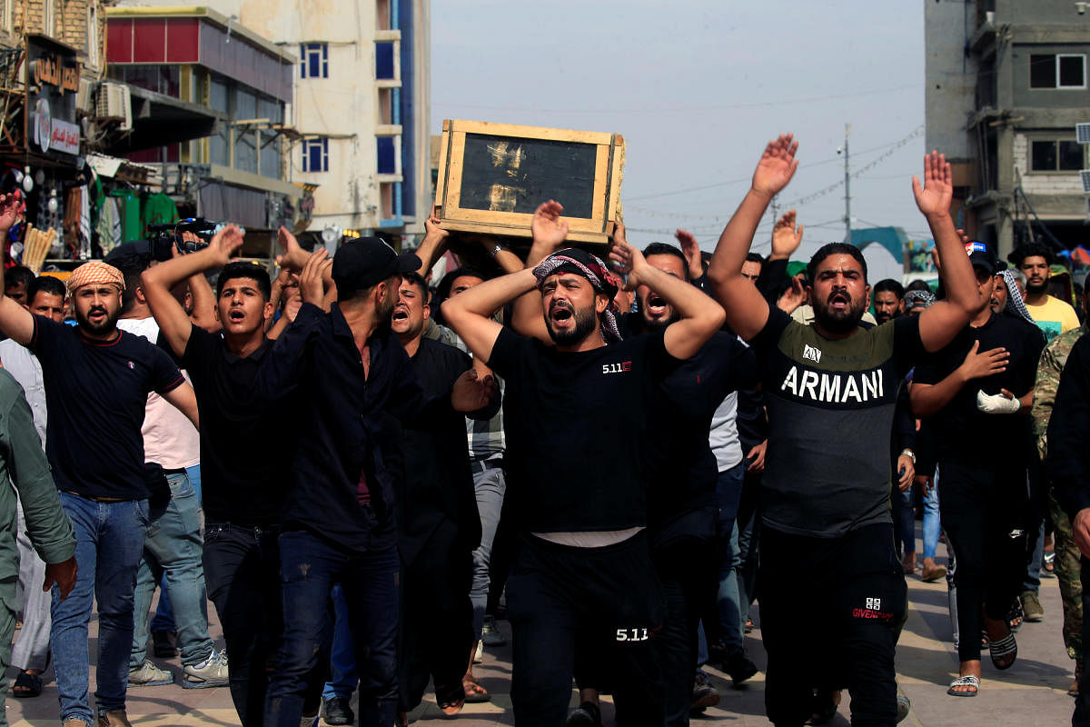 Men react as they carry the coffin of a demonstrator who was killed during anti-government protests, in Najaf, Iraq October 27, 2019. REUTERS/Alaa al-Marjani