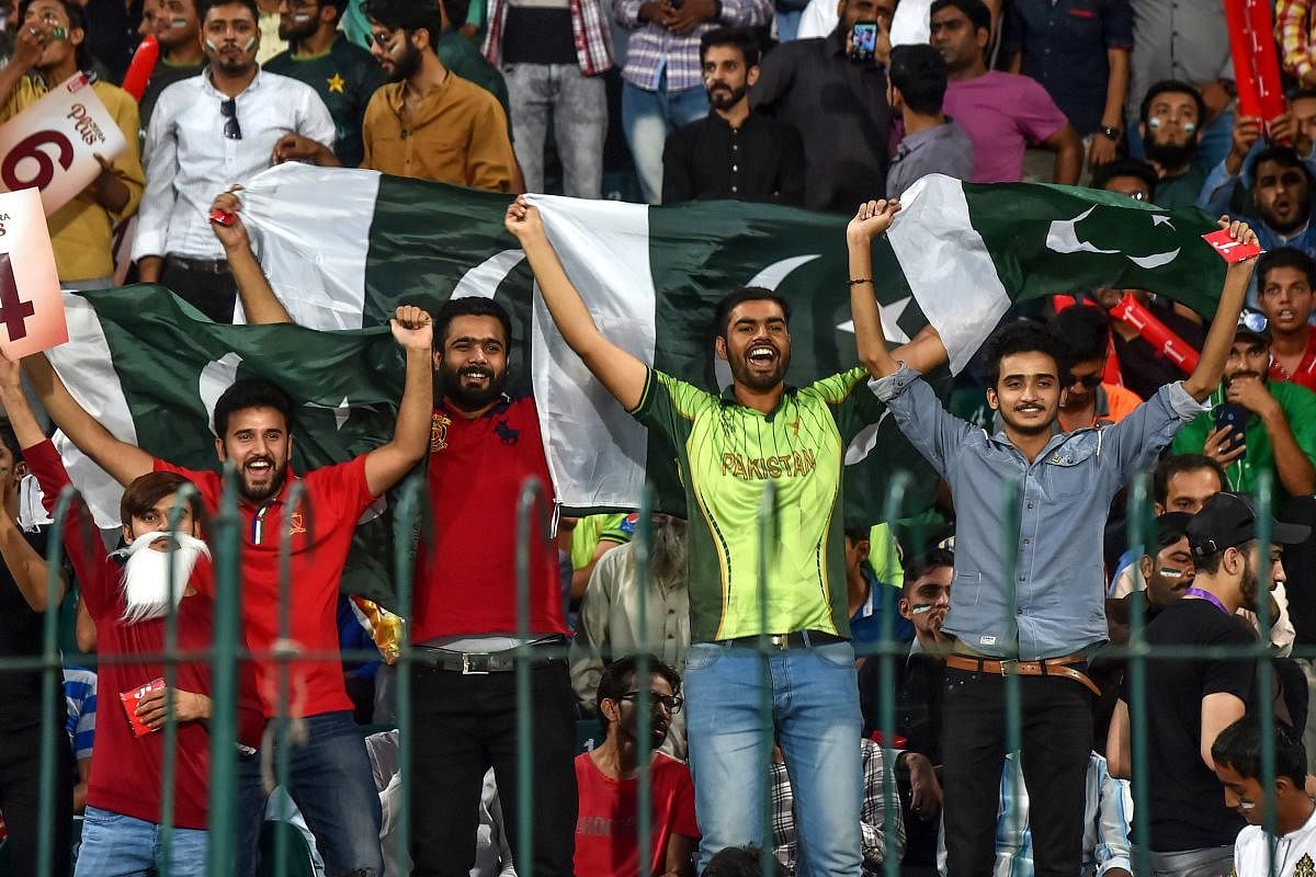 Spectators hold Pakistani flags as they cheer during the third and final Twenty20 International cricket match between Pakistan and Sri Lanka at the Gaddafi Cricket Stadium in Lahore on October 9, 2019. AFP file photo