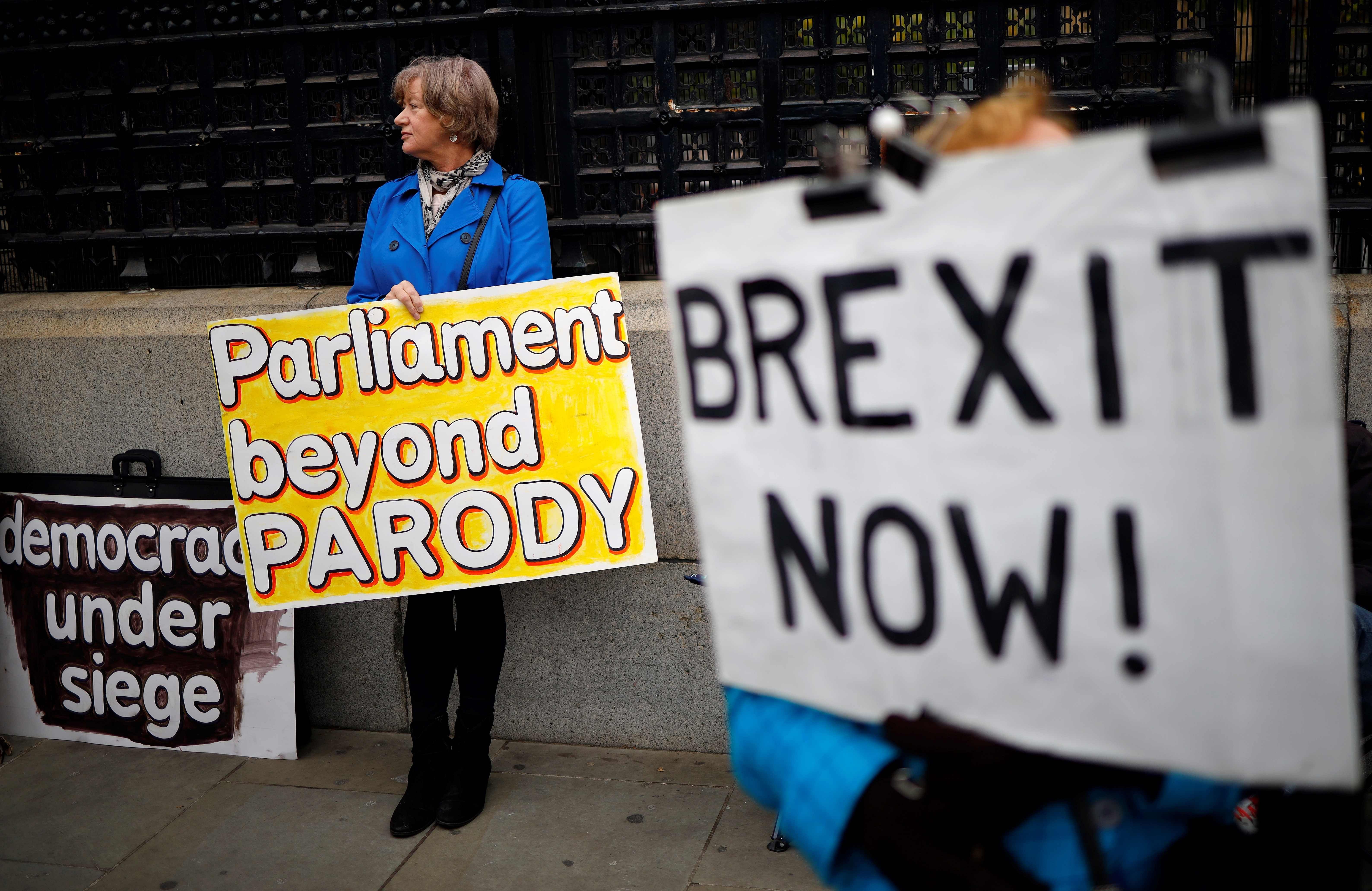Pro-Brexit activists hold placards as they demonstrate outside the Houses of Parliament in London. (AFP Photo)