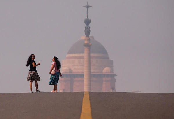 Women walk in front of India's Presidential Palace on a smoggy morning in New Delhi. (Reuters photo)