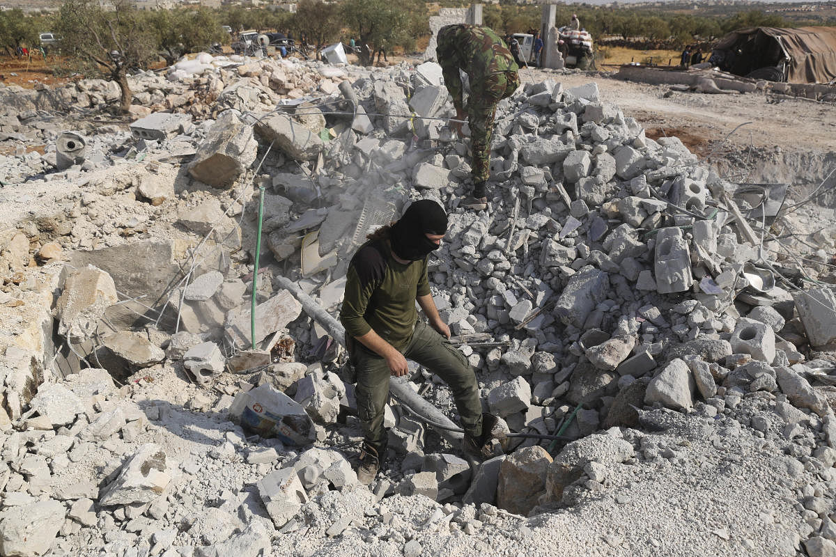 People look at a destroyed house near the village of Barisha, in Idlib province, Syria, Sunday, Oct. 27, 2019, after an operation by the U.S. military which targeted Abu Bakr al-Baghdadi, the shadowy leader of the Islamic State group. (AP/PTI)