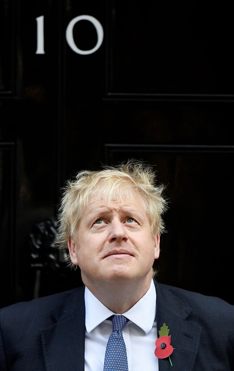 Britain's Prime Minister Boris Johnson reacts as he poses for a photo during a meeting with fundraisers for the Royal British Legion outside Downing Street in London. (Reuters Photo)