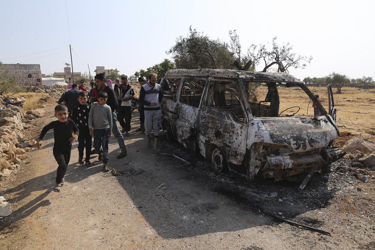 People look at a destroyed van near the village of Barisha, in Idlib province, Syria, Sunday, Oct. 27, 2019, after an operation by the U.S. military which targeted Abu Bakr al-Baghdadi, the shadowy leader of the Islamic State group. (AP/PTI)
