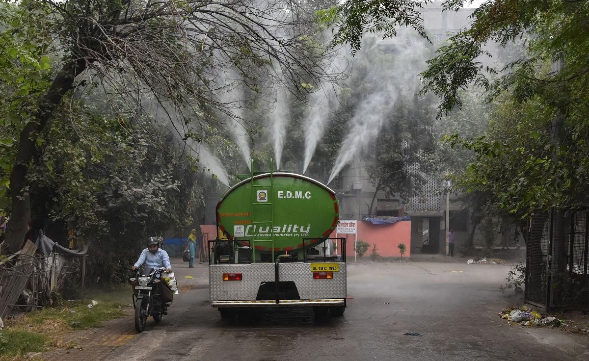 A water tanker sprays water into the atmosphere to curb rising pollution at Gautam Puri in New Delhi, Tuesday, Oct. 29, 2019. (PTI Photo)