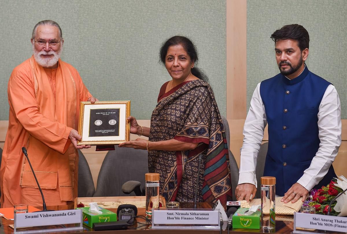 Union Finance Minister Nirmala Sitharaman presents a commemorative coin to Swami Vishwananda Giri on completion of 125th Birth Anniversary of Paramahansa Yogananda, in the presence of MoS Finance Anurag Thakur, in New Delhi on Tuesday. (PTI Photo)