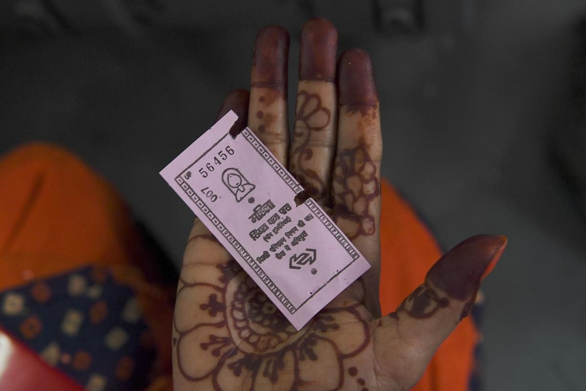  woman travelling on a Delhi Transport Corporation bus shows a pink ticket in New Delhi on October 29, 2019, allowing her to a free ride following a Delhi goverment travel scheme distributing free bus tickets for women safety and empowerment. (AFP)