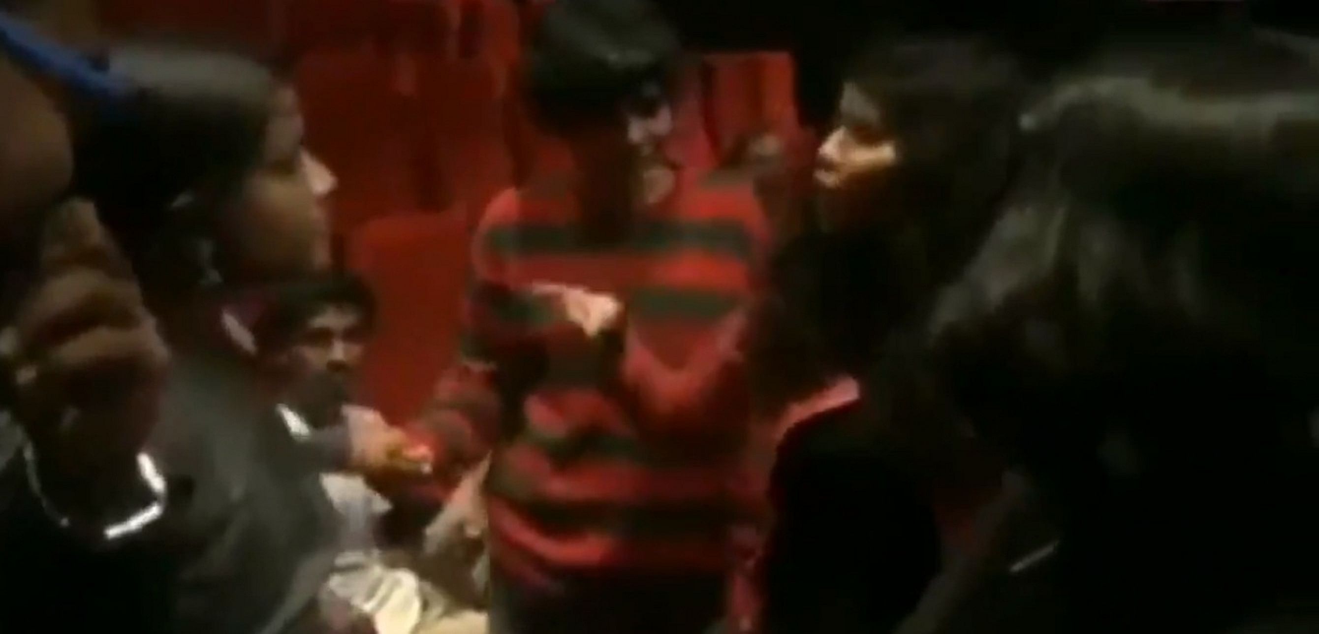 A screengrab from the video that shows a crowd of people heckling a group at a theatre for not standing for the National Anthem.