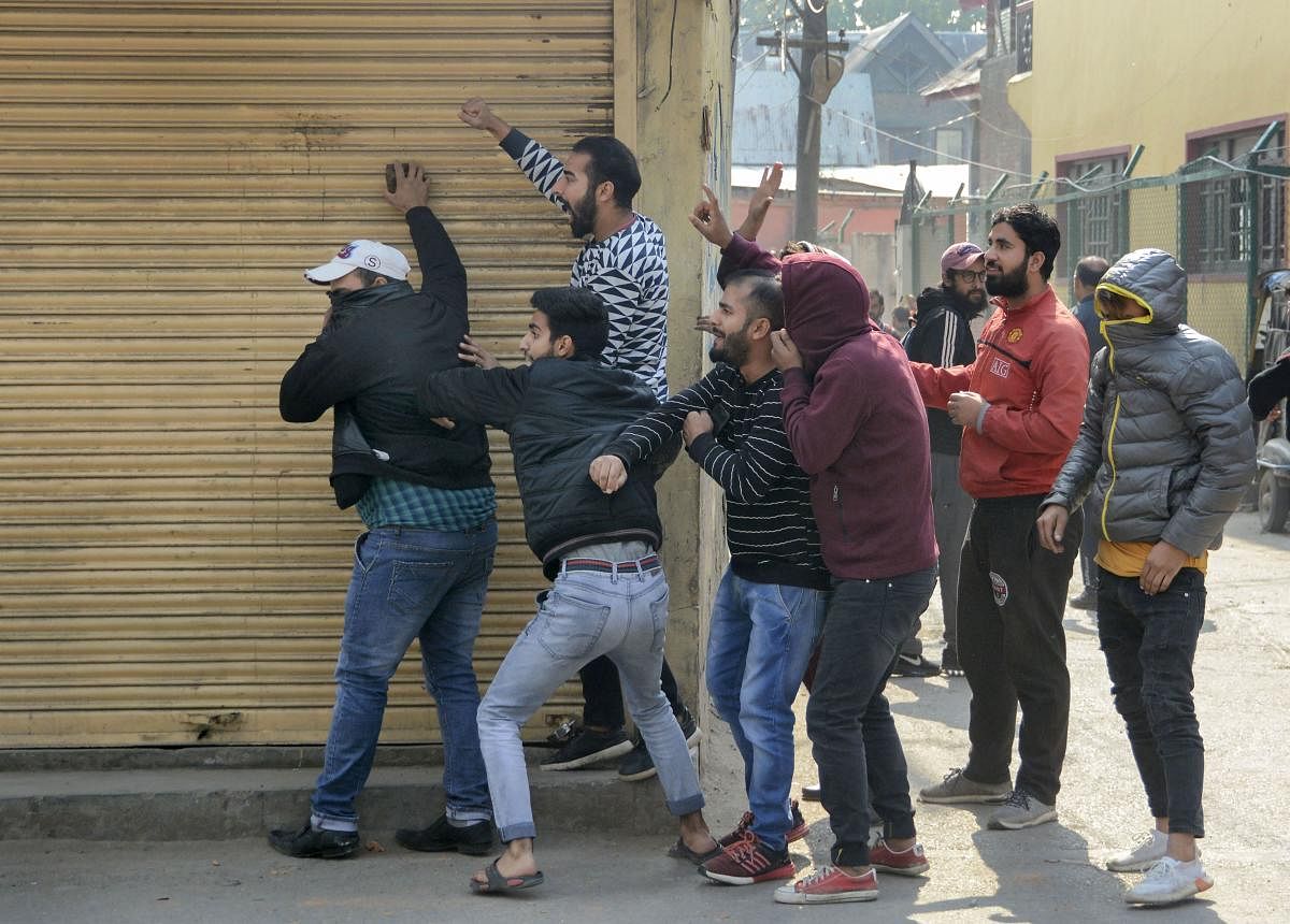 Youth throw stones towards security personnel during a protest in Srinagar. (PTI Photo)