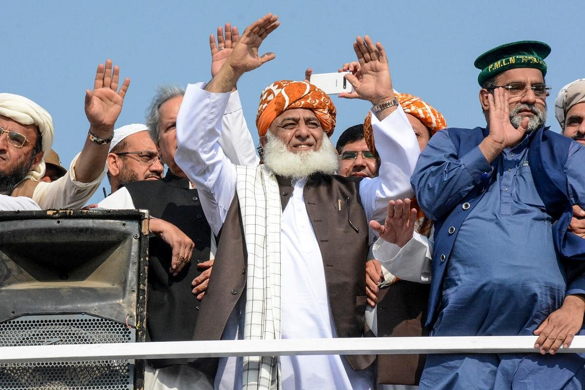 Chief of the Jamiat Ulema-e-Islam party Maulana Fazlur Rehman (C) gestures to supporters on his arrival during an anti-government "Azadi March" march towards Islamabad. (AFP Photo)