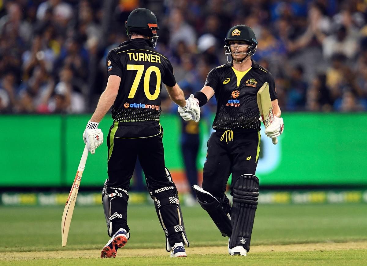 Australia's David Warner celebrates scoring 50 runs against Sri Lanka with teammate Ashton Turner (L) during their Twenty20 cricket match played in Melbourne on November 1, 2019. (Photo by WILLIAM WEST / AFP)