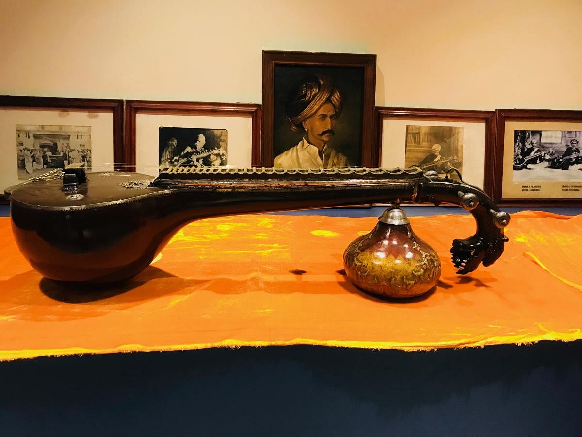 The veene belonged to Veene Sheshanna, whose likeness painted by  Raja Ravi Varma can be seen in the background. Location: Manjusha  Antique Museum at Dharmasthala