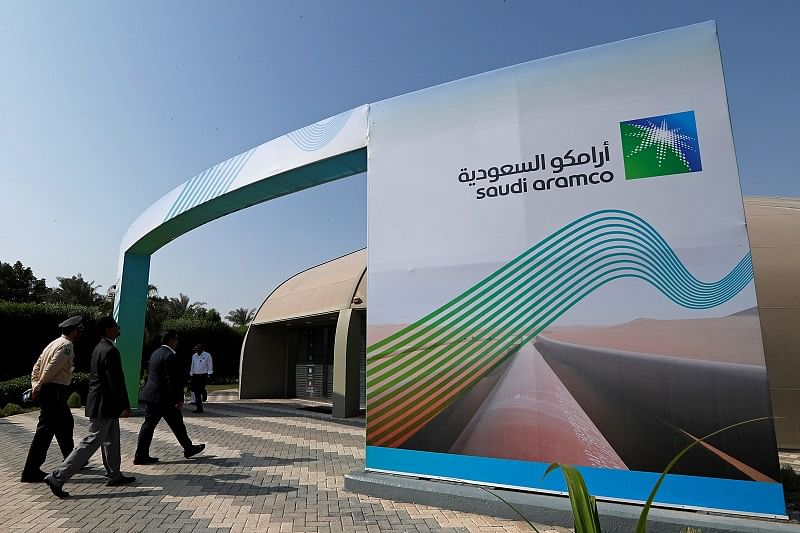 The logo of Aramco is seen as security personnel walk before the start of a press conference by Aramco at the Plaza Conference Center in Dhahran, Saudi Arabia. (Reuters Photo)