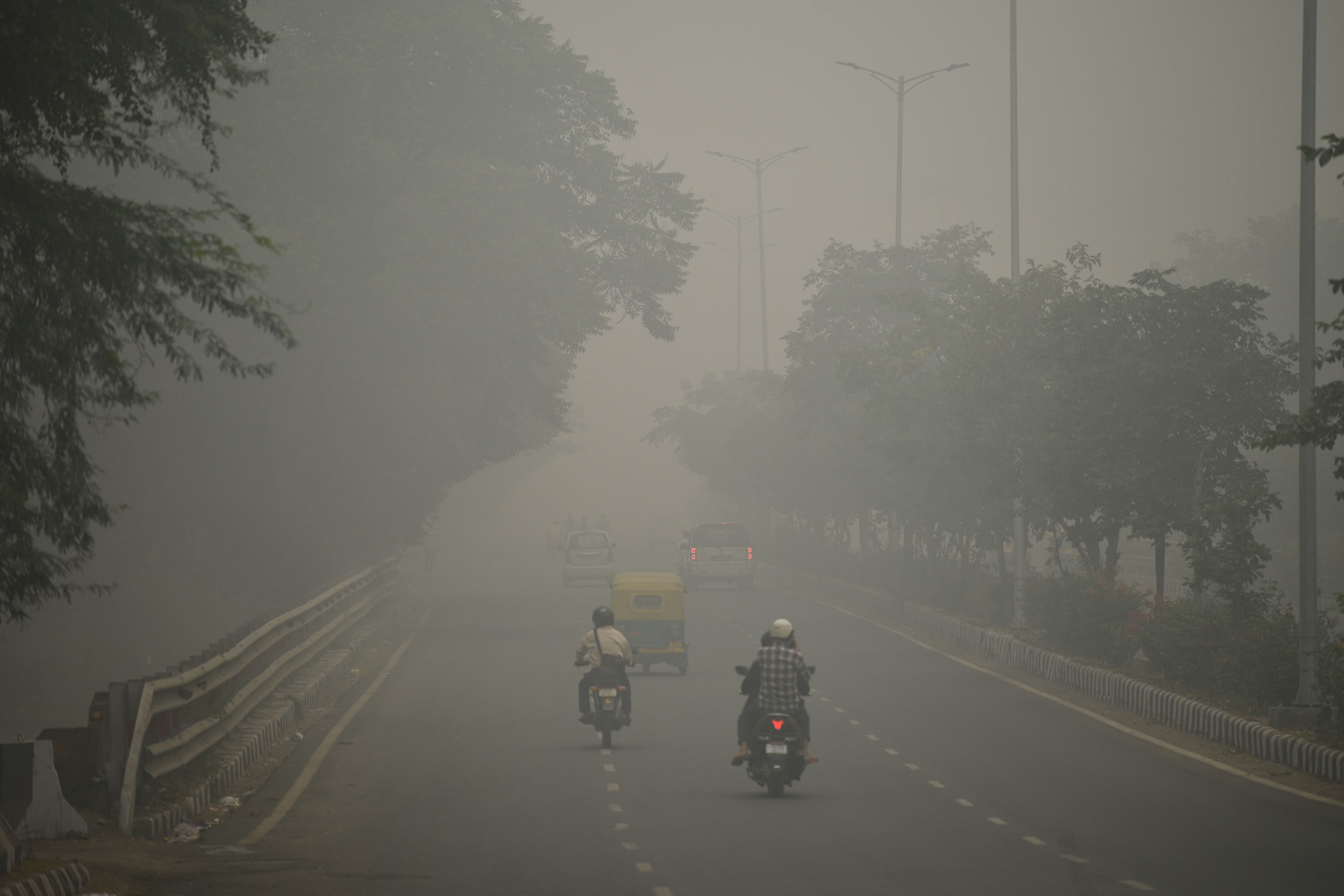Motorists drive along a road under heavy smog condition in New Delhi. (AFP Photo)